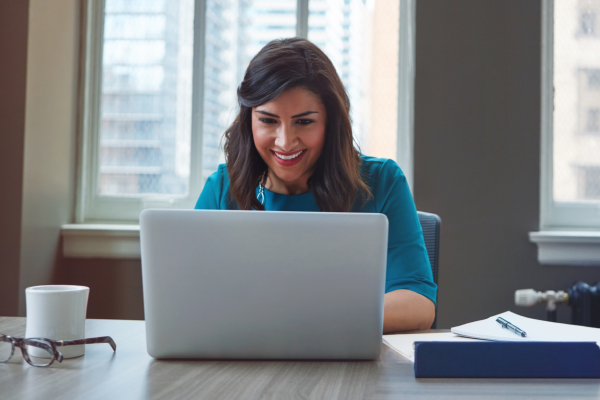 Woman typing on a computer with a smile on her face