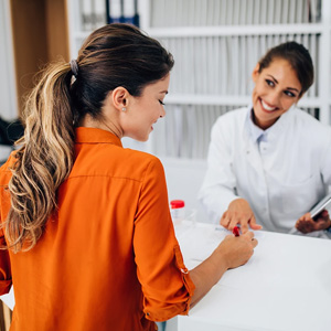In a doctor's office, a woman engages in conversation with her doctor.