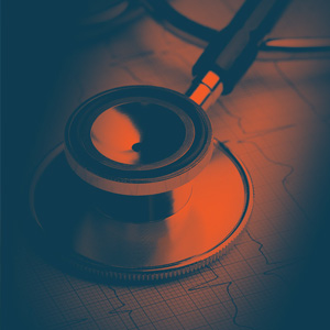 A stethoscope rests on top of an electrocardiogram (ECG) printout.