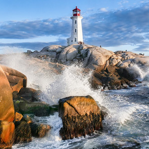 Lighthouse on a rocky shoreline with waves crashing