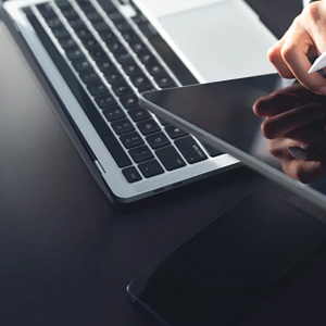 Tablet and laptop on a desk with stylus in use