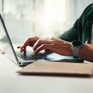 A person focused on typing on a laptop