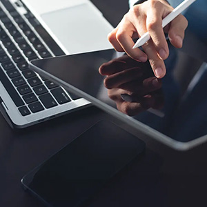Person using a tablet while holding a pen.