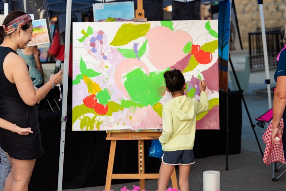 A child paints a public piece of art.