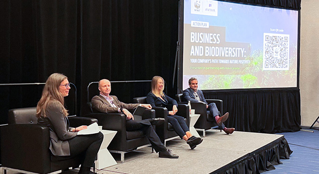 Two women and two men sitting on a stage, next to a projection that says Action Plan Business and Biodiversity: Your company’s path toward nature positivity. Presented in partnership with Aviva Canada. 